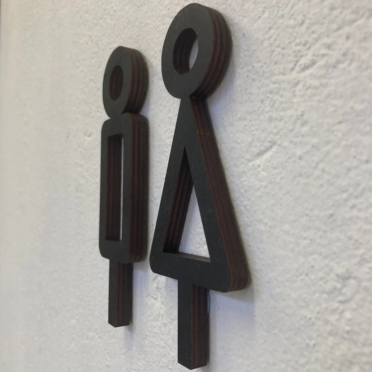 Puinen minimalistinen wc-kyltti toimiston sisustukseen.